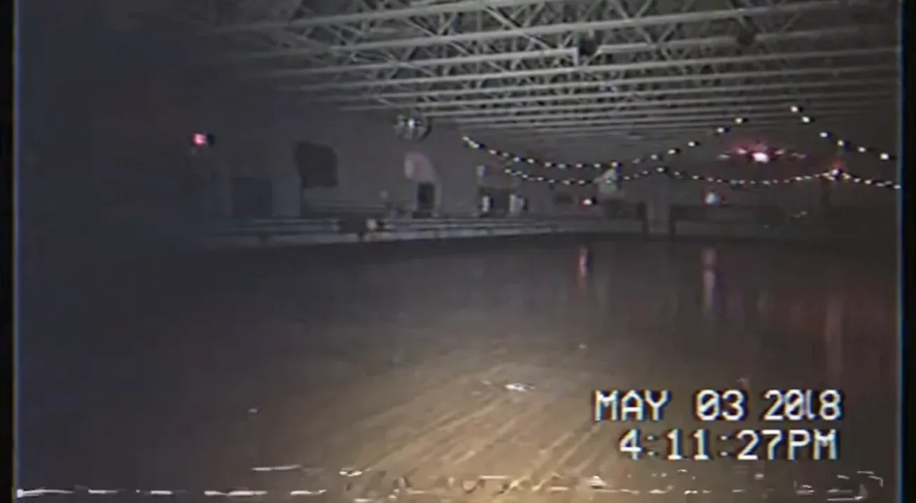 Real life Authentic raw VHS camcorder footage from the 2000s, recorded directly onto magnetic tape — not playback on a TV. The image has soft blur, muted colors, analog noise, faint static, and occasional horizontal tracking lines near the bottom. Slight handheld camera motion with natural jitter. Subtle chroma bleeding, color drift, and scanline flicker give it a genuine analog feel. Timestamp overlay with seconds in small white digital text is locked in the bottom-right corner, perfectly stable and unaffected by camera movement, static, or distortion. The timestamp never glitches, warps, or disappears — it remains consistently visible throughout. The audio has a low hiss, faint tape hum, and distant ambient noise captured from the camcorder’s built-in microphone. Looks exactly like genuine VHS footage, not a digital filter — 📼 “MAY 03 2003 4:11:27 PM – VHS camcorder footage exploring an abandoned roller rink, colored lights still faintly glowing, camera footsteps echo through the room.”

Ahh yes; the year 20l8…